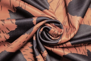 Detailed macro shot of leopard print fabric with orange-brown and black silk texture
