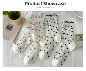 Detail of four pairs of white mesh crew socks featuring heart and dot patterns for women