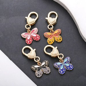 Detail of colorful butterfly alloy charms with heart-shaped lobster clasps in four shades
