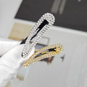 Macro shot of silver and gold rhinestone-studded snap hair clips with fine metal craftsmanship