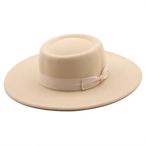 Detail of beige wool felt fedora featuring a wide brim and ribbon bow decoration