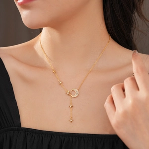 Detail of gold Y-shaped necklace featuring zircon crescent moon and star charms on neck