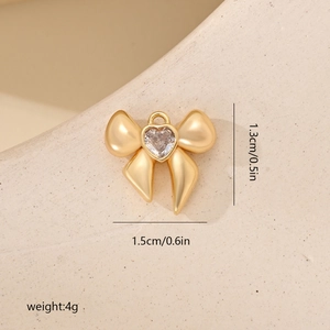 Detalle del colgante de lazo dorado con circón de corazón, mide 1,5x1,3cm y pesa 4g