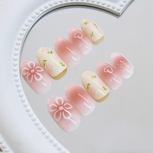 Pastel cream floral press-on nails with pink gradient heart and starburst patterns