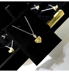 Detailed view of yellow heart-shaped pendant with pear-cut zircon on silver chain
