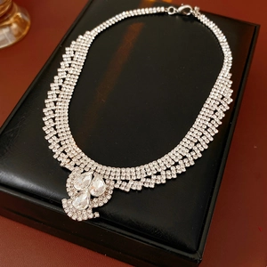 Macro view of silver water drop necklace with sparkling crystals on black display box