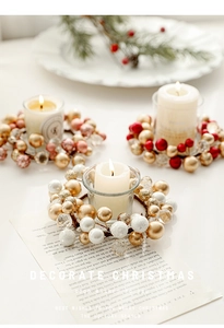 Close-up of golden and red berry Christmas candle ring wreath on a warm table