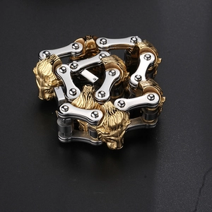 Detailed close-up of lion head motor chain bracelet in gold and silver steel finish