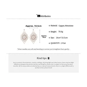 Detailed view of oversized diamond-encrusted hollow dangle earrings with silver needles