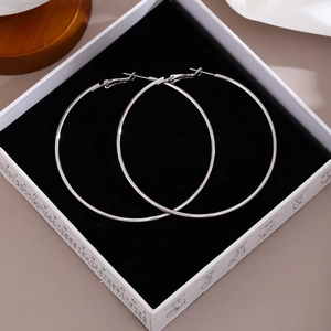 Detailed view of silver hoop earrings with polished mirror finish in a black gift box