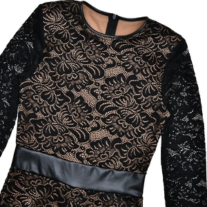Close-up of floral black lace bodysuit with beige lining and faux leather trim accents
