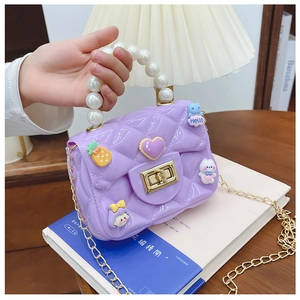 Detail of purple jelly crossbody bag with pearl handle and cute cartoon charms