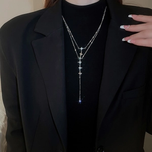 Detail of a double-layered stainless steel Y-necklace with sparkling star pendants