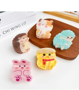 Macro detail of various animal shaped acetate hair claws in pastel colors with marble textures