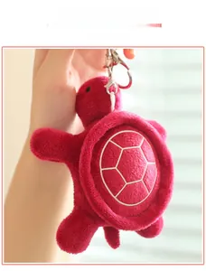 Detail of red plush sea turtle pendant with white honeycomb shell patterns and silver clasp