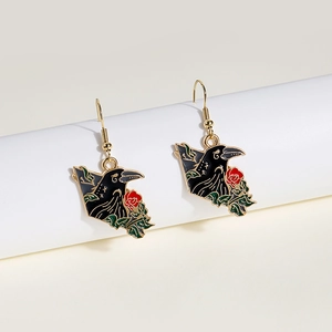 Gothic style raven and red rose earrings with detailed enamel finish on a display stand