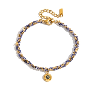 Détail du charm œil protecteur plaqué or 18 carats et bracelet en corde tressée