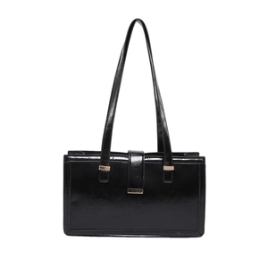 Minimalist black patent leather baguette bag with metal buckle and shoulder strap