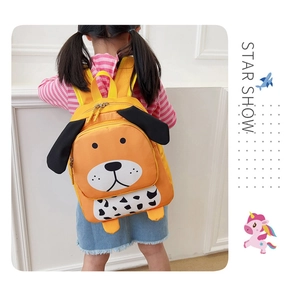 Primer plano de una linda mochila infantil de perro amarillo llevada por una niña pequeña