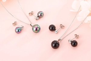 Detail view of pearl and rhinestone jewelry sets with necklaces and earrings on pink background