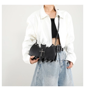 Gothic bat-shaped shoulder bag with metal chain strap and cross pendant on model
