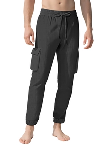 Detail of men's black cargo pants featuring textured fabric, drawstring waist and side pockets
