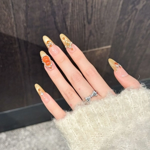 Amber gold press-on nails with luxury rhinestones and champagne gradient on long almond shape