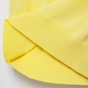 Dettaglio ravvicinato della maglia polo giallo limone con trama a costine di qualità