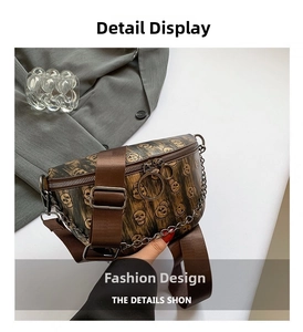 Detail of dark brown vintage fanny pack with skull print and metal chain accents