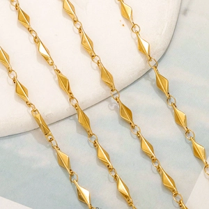 Close-up of golden geometric diamond-shaped links on a minimalist stainless steel chain