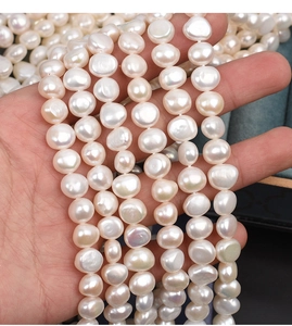 Close-up of 9-10mm natural baroque freshwater pearls with high luster in hands
