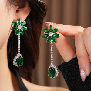 Detailed close-up of luxury green teardrop earrings with silver-plated flower pattern