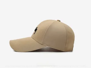 Side view of a khaki baseball cap with curved brim and black script logo embroidery