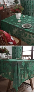 Detail of green Christmas lace tablecloth featuring reindeer and snowflake patterns