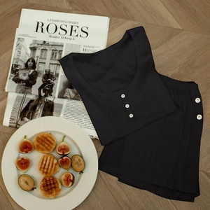 Vue à plat d'un pyjama noir en tricot avec détails boutonnés sur sol en bois