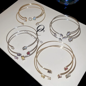Detail of three-piece set cubic zirconia bangles featuring star and teardrop charms