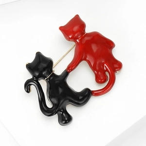 Close-up of cute black and red enamel cat brooch with gold-tone alloy backing detail