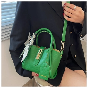 Détail du sac seau vert en cuir grainé avec fermoir doré et poignée en soie