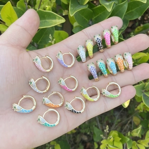 Colorful enamel snake hoop earrings with zircons and green gem eyes held in hand