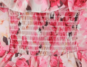 Detailed macro shot of pink floral chiffon fabric featuring elastic smocked stitching detail