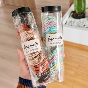 Colorful woven elastic hair ties set in transparent jars with black lids