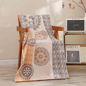 Serviette de bain couverture en gaze de coton motif mandala drapée sur chaise en bois