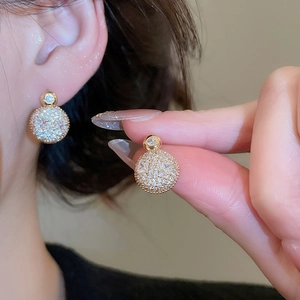 Close-up of gold-plated silver stud earrings featuring full-set sparkling zircon spheres
