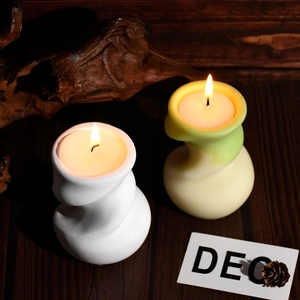 Détail de bougies parfumées torsadées allumées sur un socle en bois rustique