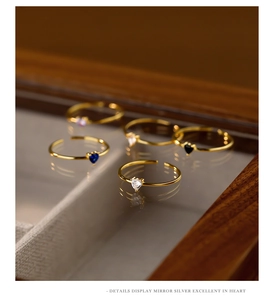 Detail showing five adjustable heart zircon rings in various colors on a luxury display