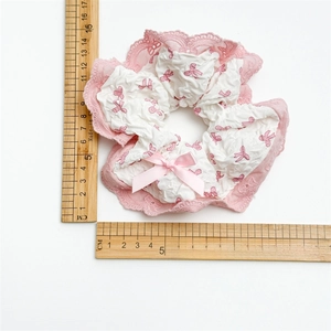 Lace bow scrunchie with pink ribbon and white fabric, shown with ruler for size measurement