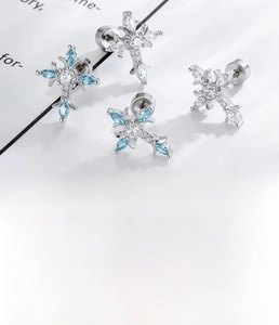 Macro shot of silver zircon cross studs with titanium steel post and disc backings
