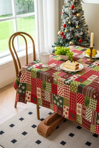 Detailed view of Christmas patchwork tablecloth with reindeer, snowflake, and plaid patterns