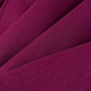 Gros plan détaillé du tissu en laine bordeaux montrant la texture douce et la fibre