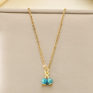 Macro detail of dopamine style dragon fruit pendant necklace in blue and gold finish